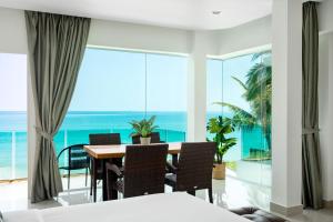 a dining room with a table and a view of the ocean at 4U Resort Samui in Lamai
