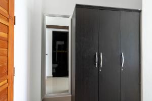 a black cabinet with a mirror in a room at 4U Resort Samui in Lamai