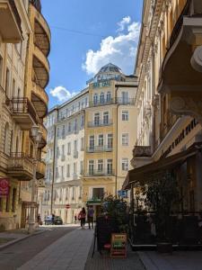 una via cittadina con edifici e persone che camminano per strada di Hotel Flora a Mariánské Lázně