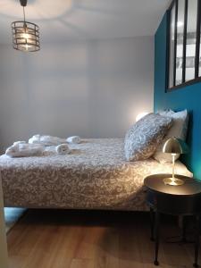 una camera con letto e tavolo con lampada di La métairie du rumain a Hengoat