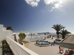 Una vista de un resort con piscina y palmeras. en El Mijo Alojamiento, en Tías