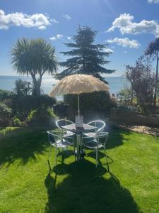 a table and chairs under an umbrella on a lawn at Carlton Hotel in Shanklin