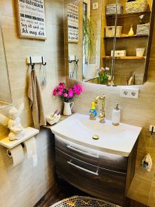 ein Bad mit einem Waschbecken und einem Spiegel in der Unterkunft Extravagantes Apartment in Potsdam