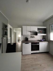 uma cozinha com armários brancos e um forno com placa de fogão em Ferienhaus-Ost em Giessen