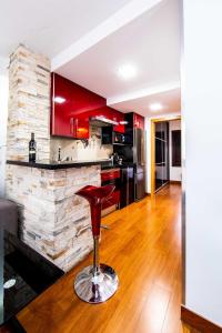 a kitchen with red cabinets and a bar stool at ALBAICIN GLORIA DREAMS. A LOS PIES DE LA ALHAMBRA in Granada