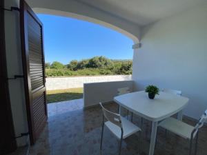een witte tafel en stoelen in een kamer met uitzicht bij Casa Relax - Sas Murtas Posada in San Lorenzo