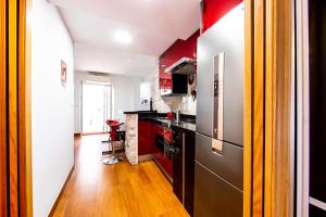 eine Küche mit roten Schränken und einem schwarzen Kühlschrank in der Unterkunft ALBAICIN GLORIA DREAMS. A LOS PIES DE LA ALHAMBRA in Granada
