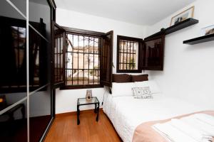 a bedroom with a bed and windows at ALBAICIN GLORIA DREAMS. A LOS PIES DE LA ALHAMBRA in Granada