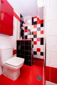 a bathroom with a toilet and a red floor at ALBAICIN GLORIA DREAMS. A LOS PIES DE LA ALHAMBRA in Granada