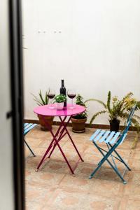 einen rosa Tisch mit zwei Gläsern Wein und zwei Stühlen in der Unterkunft ALBAICIN GLORIA DREAMS. A LOS PIES DE LA ALHAMBRA in Granada