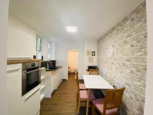 a kitchen with a table and a brick wall at Fewo Heinrichser Markt - 2 Schlafzimmer mit Sauna und Terrasse in Suhl