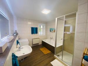 a bathroom with a tub and a sink and a shower at Fewo Heinrichser Markt - 2 Schlafzimmer mit Sauna und Terrasse in Suhl +26 photos