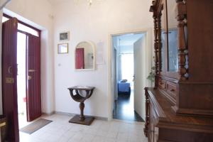 a hallway with a wooden dresser and a mirror at B&B CASAVACANZE CHIESA MADRE in Carovigno