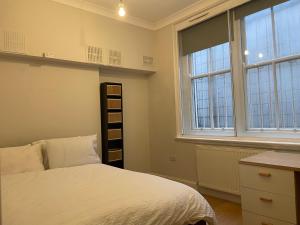 sypialnia z łóżkiem i 2 oknami w obiekcie 147 knapp road house w Londynie
