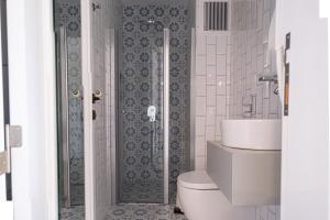 uma casa de banho com um WC, um lavatório e um chuveiro em TaşAda Hotel - Special Class em Bozcaada