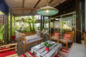 un patio con mesa y sillas en un porche en Villa de charme proche plage et lagon en La Saline les Bains