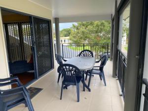 a porch with a table and chairs on a balcony at Indigo Place 1 Rainbow Beach in Rainbow Beach