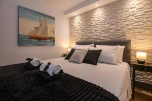 een slaapkamer met een groot bed en een scheepsschilderij aan de muur bij Ivan Apartment in Dubrovnik