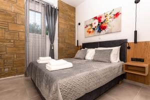 a bedroom with a bed with towels on it at Rikanthos Stone Sea View Apartment in Falelianá