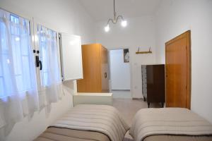 a room with two beds and a window in it at B&B CASAVACANZE CHIESA MADRE in Carovigno