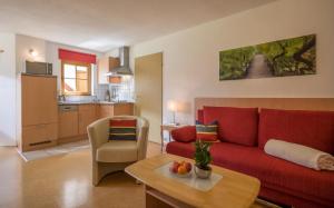 een woonkamer met een rode bank en een tafel bij Apartment Barbara in Stumm