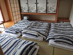 a group of three beds in a room at NOBORIBETSU no MORI in Noboribetsu