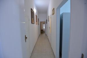 a hallway with white walls and a tile floor at B&B CASAVACANZE CHIESA MADRE in Carovigno
