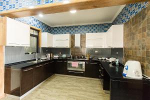 a kitchen with white cabinets and blue tiles at Shayona Apartments Limited in Nairobi