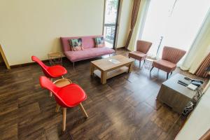 a living room with red chairs and a couch at Shayona Apartments Limited in Nairobi