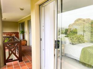 a bedroom with a view of a bed and a balcony at 34 Summerplace in Knysna
