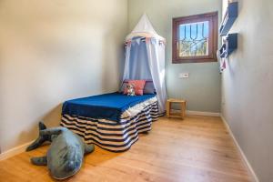 A bed or beds in a room at Casa Azul Stylish beach house for 4 adults and 1 child in Cala Llombards
