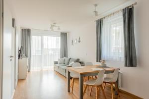 a living room with a table and a couch at Harbor 9 Apartment in Kołobrzeg