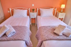 Camera con 2 letti singoli e pareti arancioni. di Vicky’s Luxury Apartment Sidari a Sidari