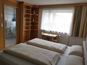 - une chambre avec 2 lits, une fenêtre et une table dans l'établissement Wei Wei's Hostel, à Ehenbichl
