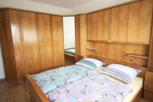 1 dormitorio con 1 cama y armarios de madera en Geräumige Ferienwohnung im Zentrum en Sankt Pölten