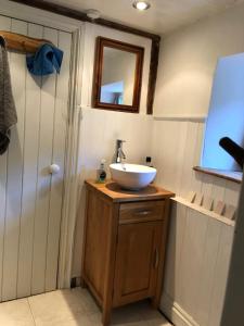 a bathroom with a sink and a mirror at Traditional 18th Century Welsh Cottage in Llandovery