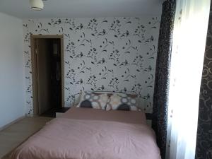 - une chambre avec un lit rose et du papier peint noir et blanc dans l'établissement Cazare la Corbu, à Corbu