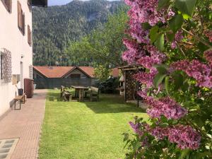a garden with a picnic table and pink flowers at CASA MARINA in Malè