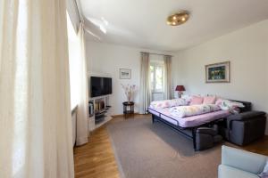 a living room with a couch and a tv at Haus Dorfblick in Caldaro