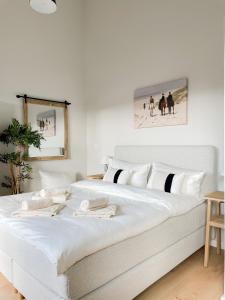 ein Schlafzimmer mit einem großen weißen Bett mit weißen Kissen in der Unterkunft Ferienwohnung The Sun Kiss in Scharbeutz