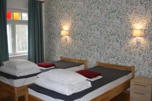 two beds in a bedroom with a wall with flowers at Posti Villa in Võsu