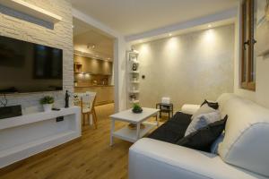 een woonkamer met een witte bank en een tv bij Ivan Apartment in Dubrovnik