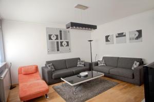 - un salon avec deux canapés et une chaise orange dans l'établissement Angel Apartment, à Belgrade