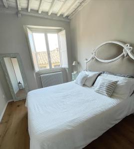 1 dormitorio con 1 cama blanca grande y ventana grande en Alberto e Costanza Suite, en Lucca