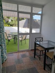 a dining room with a table and chairs and a patio at La casa de la luz in San Fernando