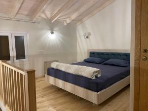 a bedroom with a large bed with a blue headboard at Valeria’s Apartments in Sinarádes