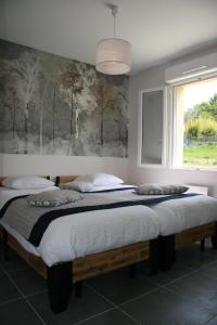 two twin beds in a bedroom with a window at Le Domaine de Louise in Seigy