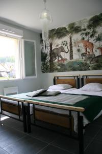 a bedroom with a large bed with a painting on the wall at Le Domaine de Louise in Seigy