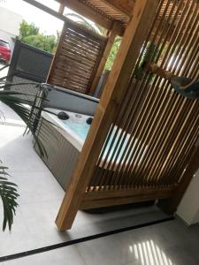 un jacuzzi fuera de una casa con terraza de madera en LE JARDIN D EDEN, en Frontignan