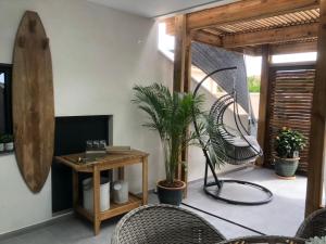 uma sala de estar com cadeiras e uma mesa com plantas em LE JARDIN D EDEN em Frontignan